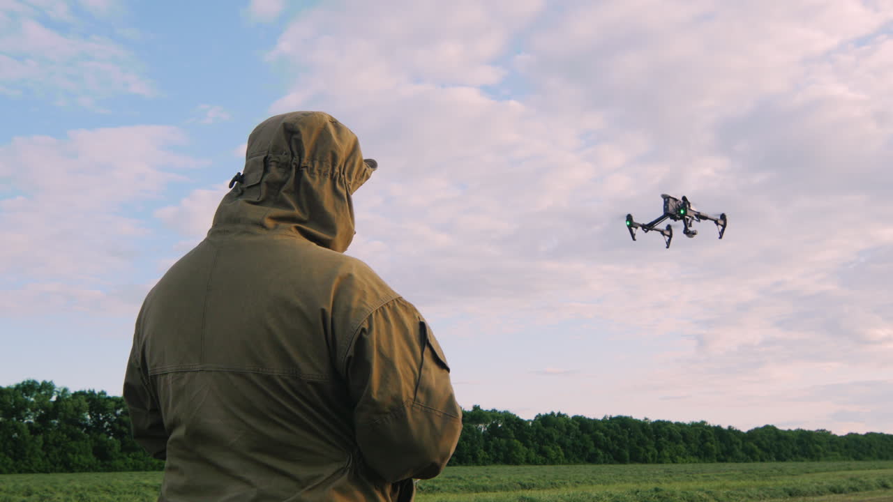 el hombre controla el dron el dron vuela alto en el cielo la cámara sigue al dron