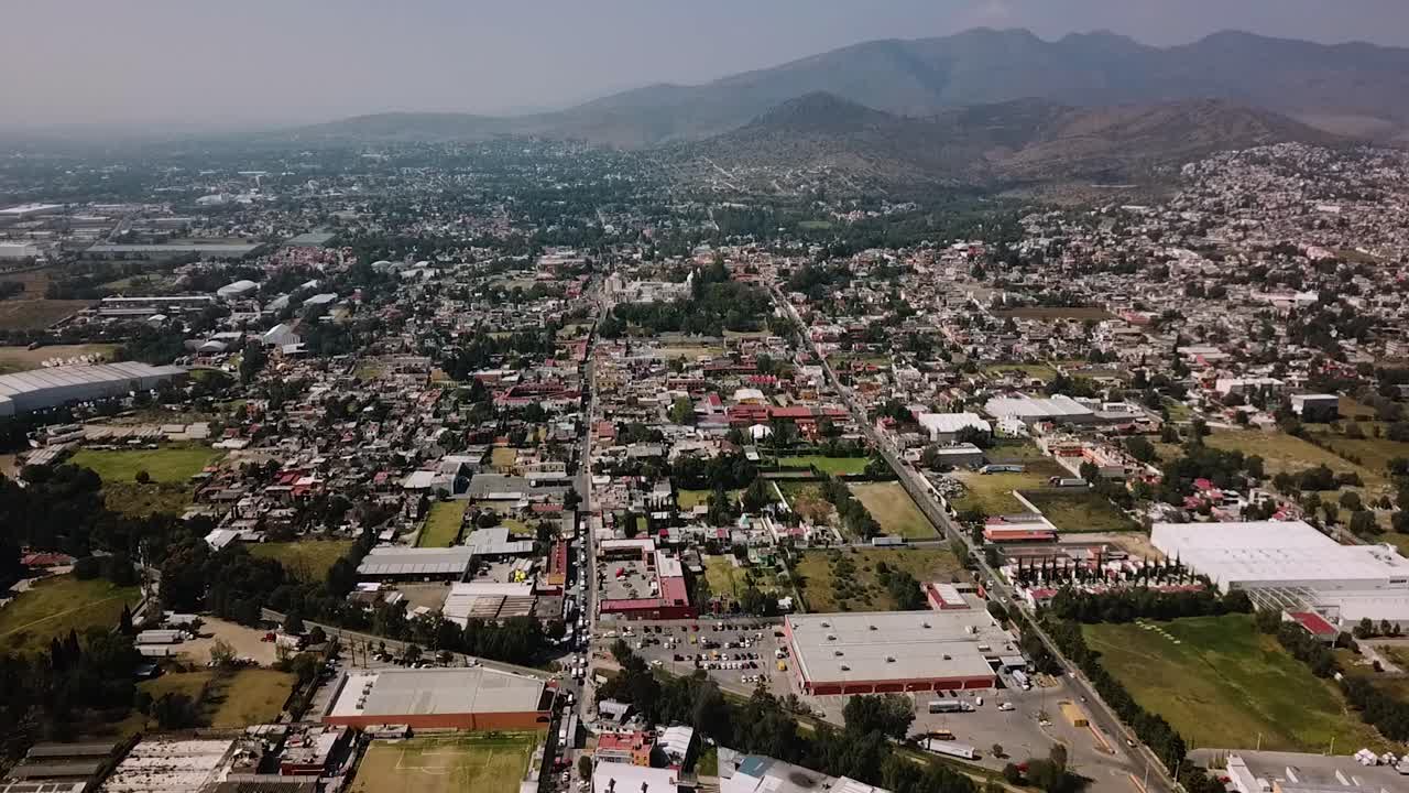 Aerial panoramic drone shot of the urban settlement of the pueblo mágico of Tepotzotlán, part of the metropolitan area of Mexico City, with the surrounding Sierra in the background