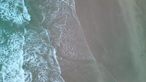 waves meeting sand from an aerial viewpoint