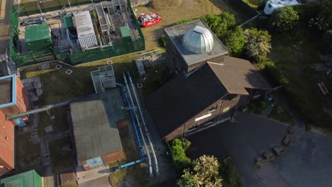 vista aérea ascendente mirando hacia abajo sobre pex hill leighton observatorio cúpula de plata techo en la cima de la colina tierras de cultivo al amanecer