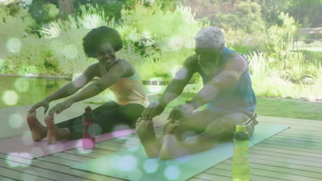 animation of light spots over african american couple doing yoga, stretching, slow motion