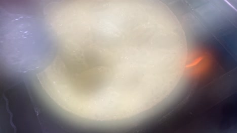 un cocinero cocinando una deliciosa salsa blanca cremosa y salada afgani momo en una cacerola a la venta en kolkata