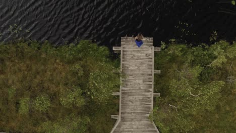 Above-of-lonely-woman-looking-around-lake-In-windy-Latvia