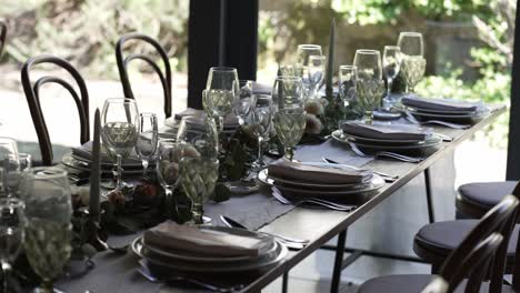 Elegante-Mesa-De-Boda-Con-Cristalería-Y-Centro-De-Mesa-Floral-Junto-A-Una-Ventana