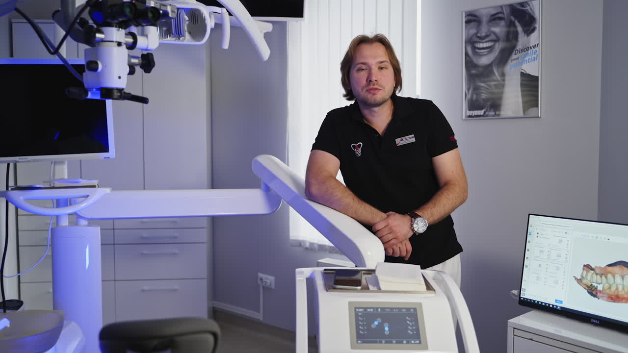 Talking male dentist in dental office. Dentist talking on camera in dental clinic