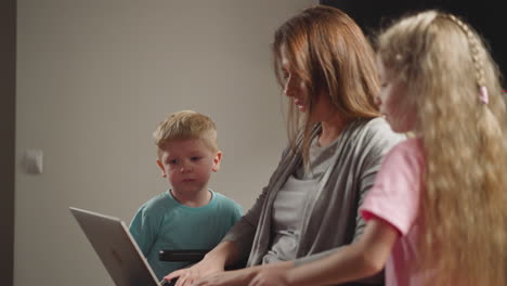 chubby toddler and long-haired girl watch mommy working