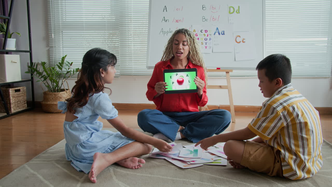 Tutor Showing Picture on Tablet to Schoolkids during Speech Therapy Session