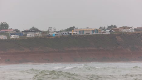 Ciudad-Costera-De-Vama-Veche-En-Un-Día-De-Niebla-En-Constanta,-Rumania-Con-Boya-Flotando-A-Través-De-Las-Olas-Del-Mar-En-Primer-Plano