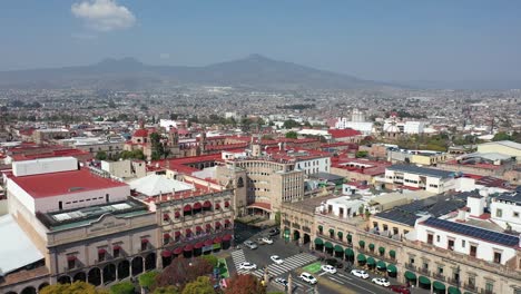 Un-Dron-Se-Retira-Sobre-El-Centro-De-Morelia,-Michoacán,-Revelando-El-Bullicioso-Paisaje-Urbano-Y-La-Arquitectura-De-Estilo-Colonial.