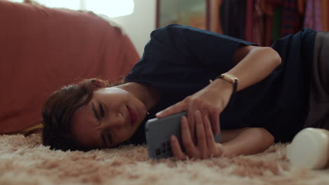 woman laying on the carpet with the phone