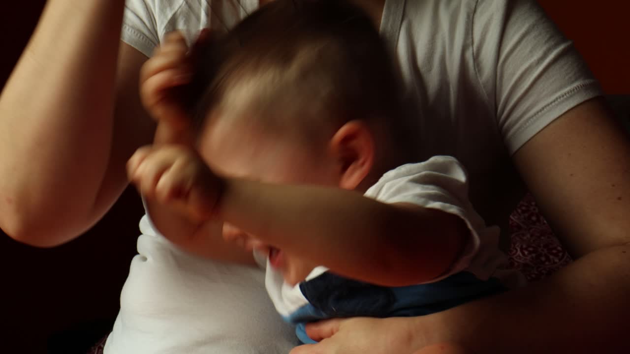 Cute Baby Boy Sits on Mom's Lap and Plays with Wire Head Massager and Laughs