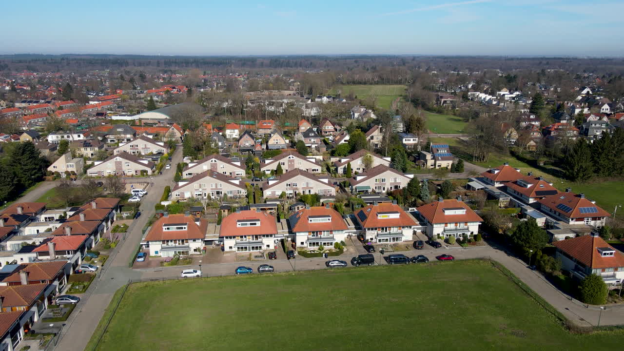 Aerial of suburban neighborhood at the edge of green meadow