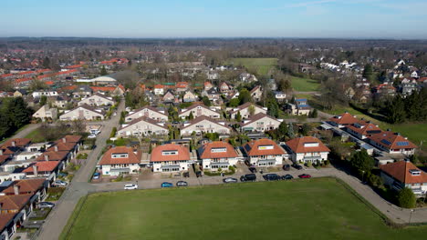 aerial of suburban neighborhood at the edge of green meadow