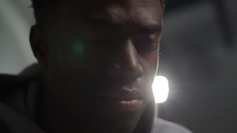 close up low key lighting shot of unhappy and depressed young man shaking head and shouting