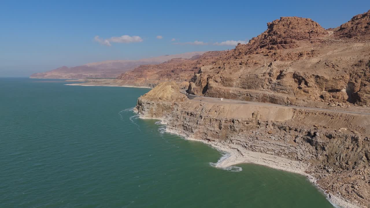 Prospettiva aerea da drone delle cristalline formazioni saline e delle vivaci acque minerali turchesi lungo le rive giordane del Mar Morto
