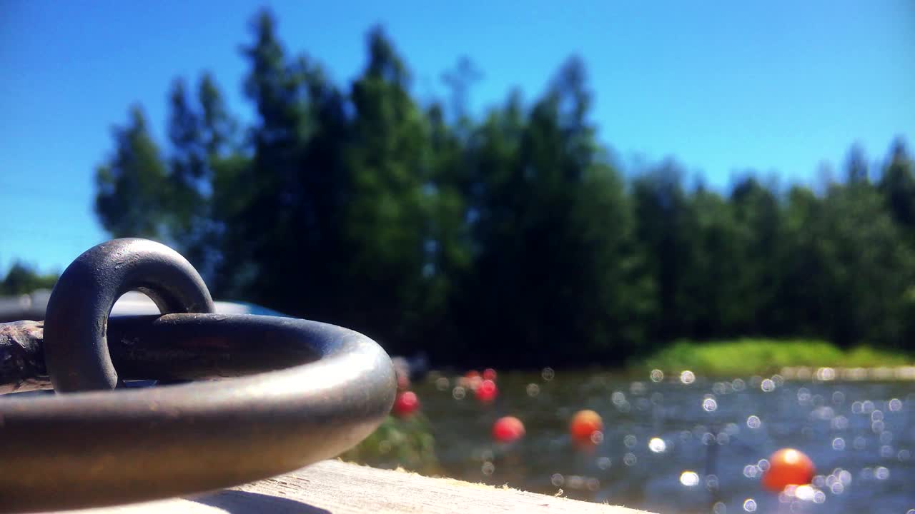 보트와 보트 부표가 배경에 떠 있는 항구에서 금속 루프를 닫습니다.