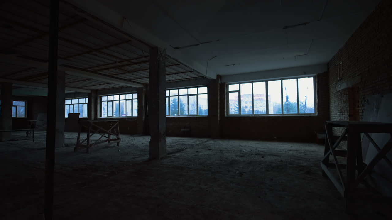 A large room with brick walls, columns and unfinished ceiling and floor. Construction of a building in progress.