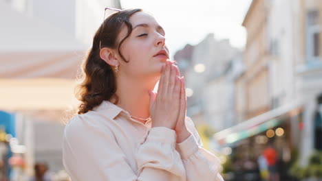 retrato de una mujer orando con los ojos cerrados a dios pidiendo bendición ayuda perdón al aire libre
