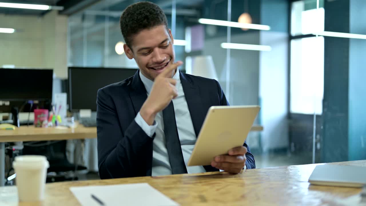 Young African Businessman having Success on Tablet