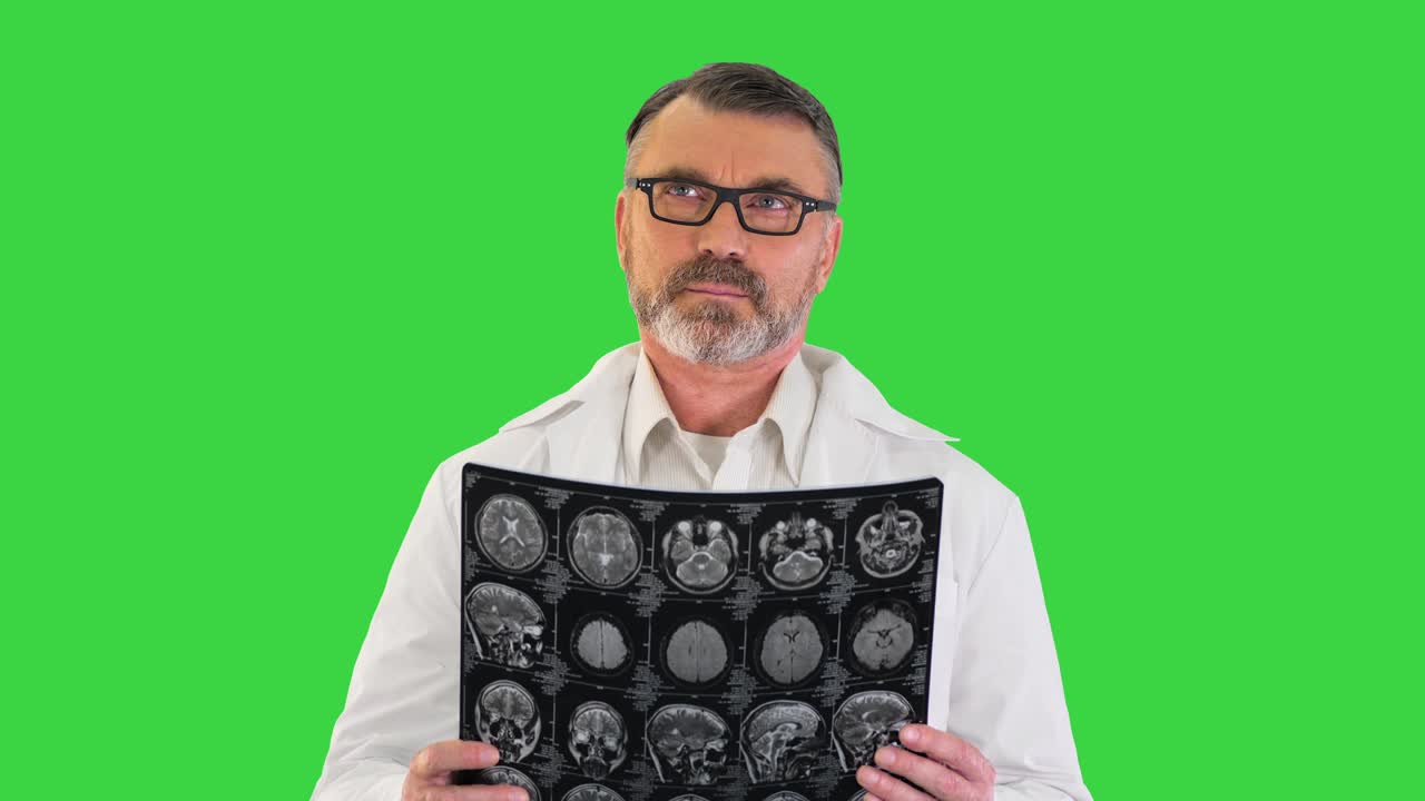 Concentrated doctor examining head brain x ray picture on a Green Screen, Chroma Key