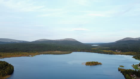 aerial descends to picturesque countryside lake in flat boreal forest