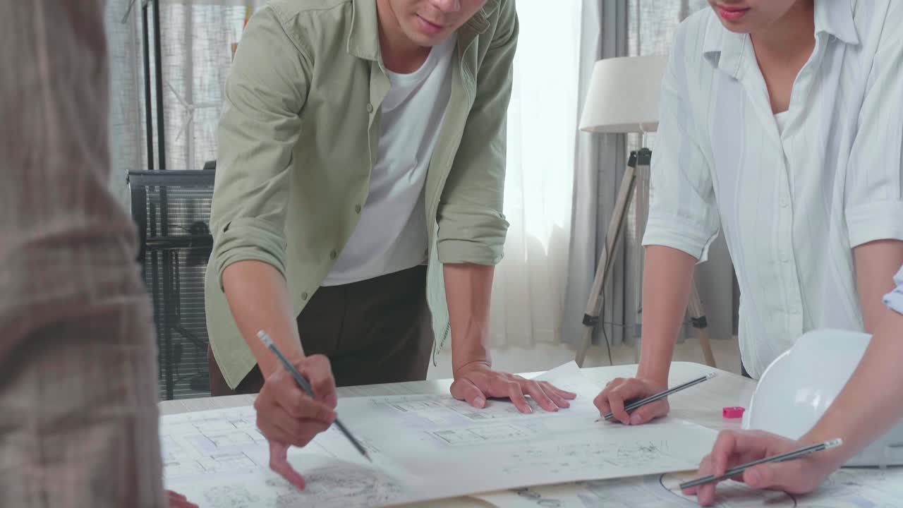 Group Of Asian Engineers Discuss About Work At The Office