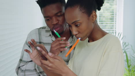 Black-couple,-phone-and-brushing-teeth-in-bathroom