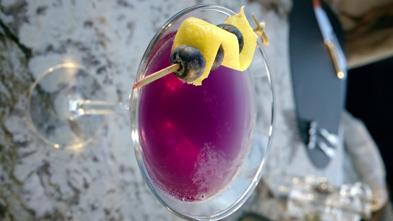 Pink red martini with blueberries on top close up