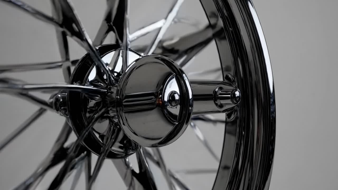 Close-up video of a shiny chrome wheel, shot from a low angle, highlighting the intricate spokes
