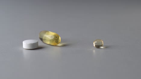 different color and shape pills on table, person take white round tablet