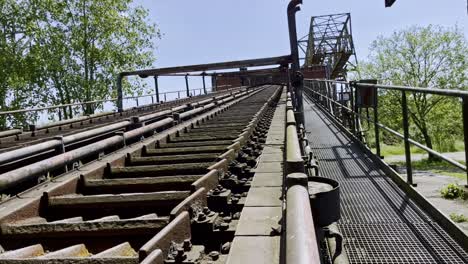 Altes-Stillgelegtes-Kohleförderband-Verrostet-Und-Umgeben-Von-Natur-Im-Landschaftspark-In-Duisburg,-Deutschland