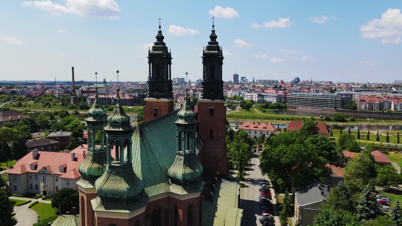 Smooth drone flyby of Poznań Cathedral with green rooftops, city in background