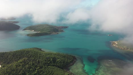 aerial: south pacific coral reef islands through thick cloud fog