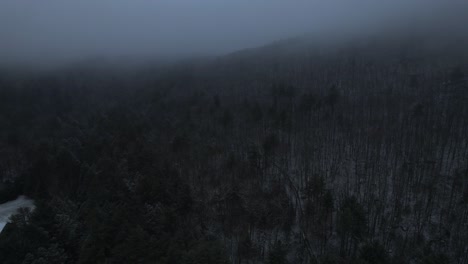 aerial drone video footage of a beautiful snowy, foggy evening with low clouds in the appalachian mountains during winter