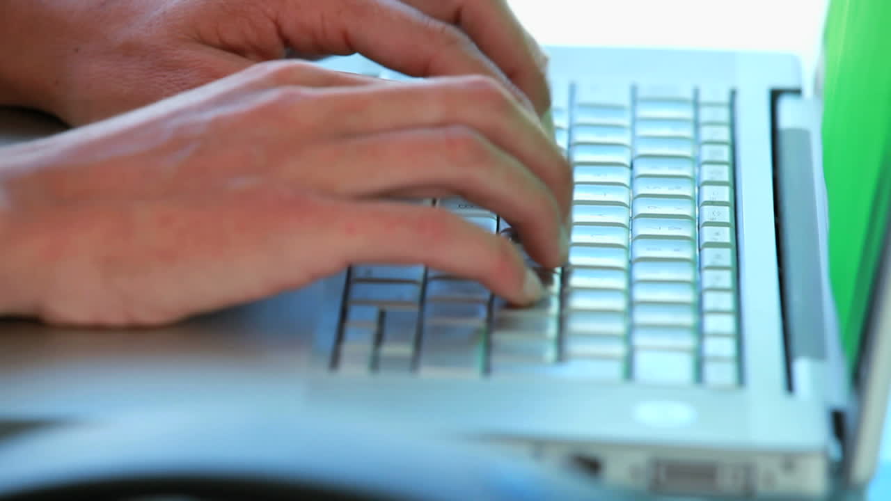 Close up on someoness hands typing on a laptop
