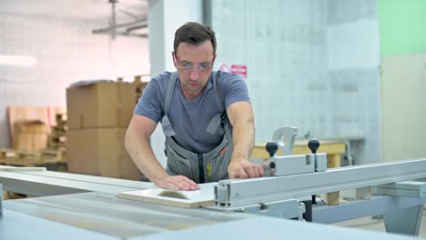joven trabaja en una sierra circular en un taller de muebles