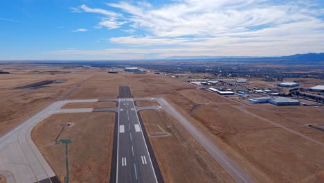 flugzeugflug, der über das südliche ende der landebahn am flughafen colorado springs fliegt