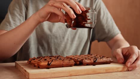 la salsa de chocolate se vierte sobre los waffles
