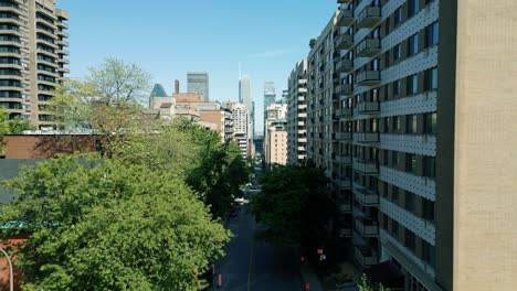 4k cinematic urban drone footage of an aerial view of a street in the middle of downtown montreal, quebec on a sunny day