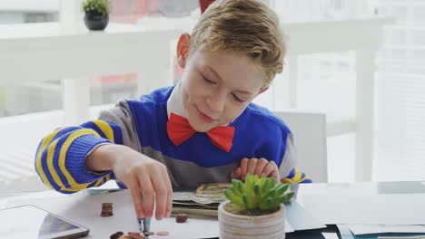 Boy-as-executive-counting-the-coins-at-desk-4K-4k