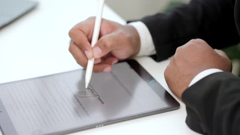 hombre de negocios firmando un contrato de negocios con un bolígrafo en una tableta. hombre firmando un acuerdo en una tablet en la oficina. concepto de negocios y tecnología. concepto de firma electrónica