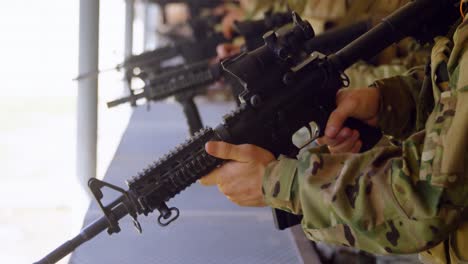 vista lateral de soldados militares de raza mixta disparando rifle en práctica de tiro durante el entrenamiento 4k