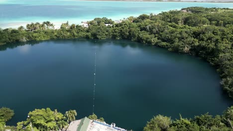 drone revelando el cenote en bacalar, méxico con la laguna de los 7 colores