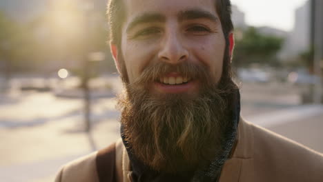 close up portrait of happy young bearded hipster man smiling cheerful enjoying city urban lifestyle commuting