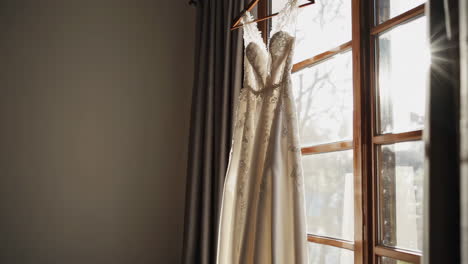 a wedding dress hanging in a room