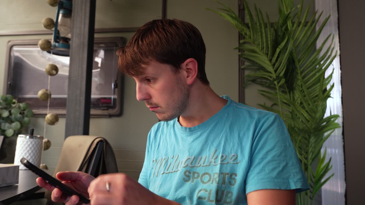 Man using his phone to navigate social media is taken aback by something he finds