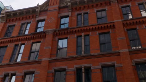 a beautiful smooth driving shot of a red brick building in a downtown area