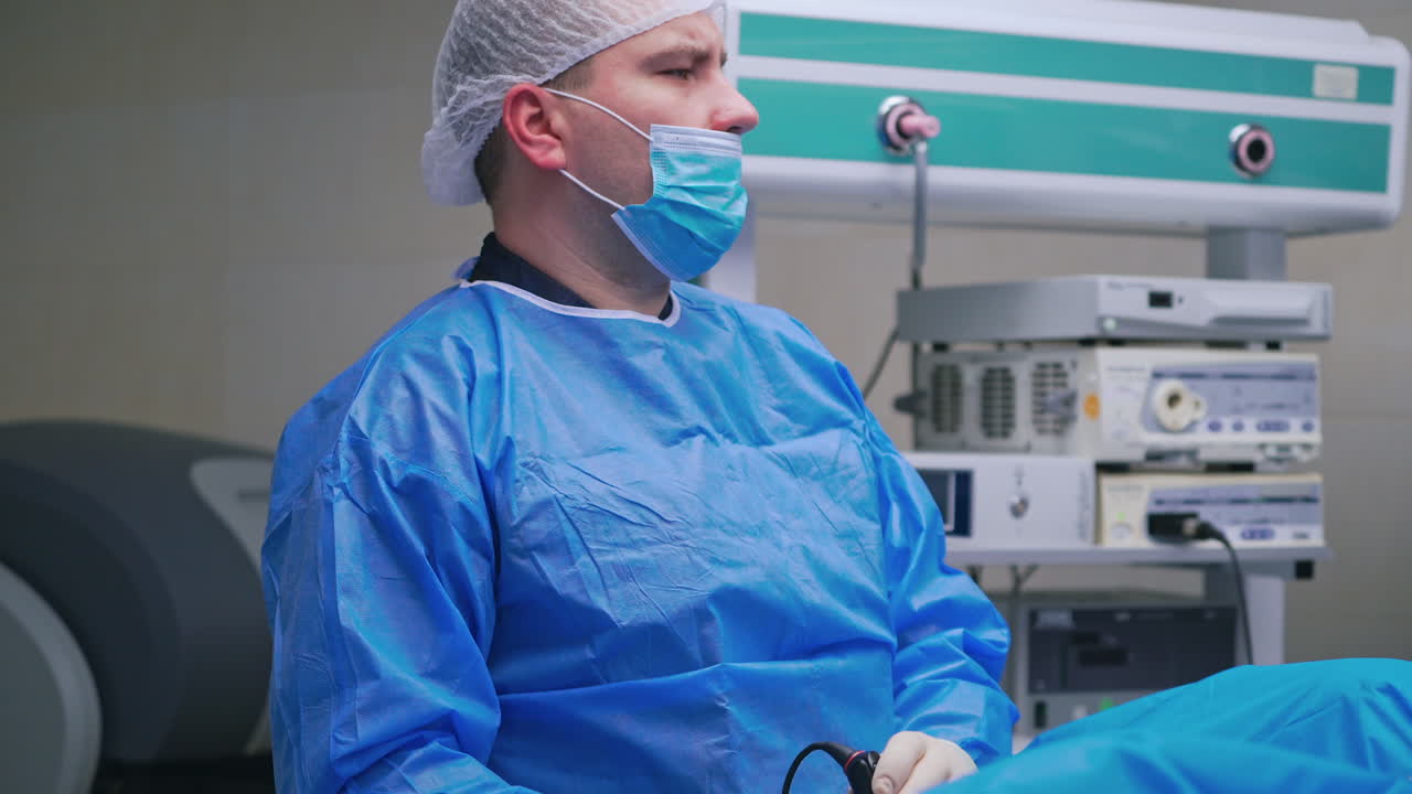 Surgeon doing an operation. Doctor and a nurse in medical uniform on the modern medical equipment background in the surgery room.