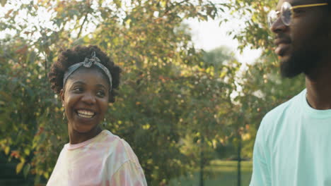 amigos afroamericanos caminando y charlando en el parque en un día de verano