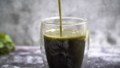 cerca de verter batido de desintoxicación verde en glas